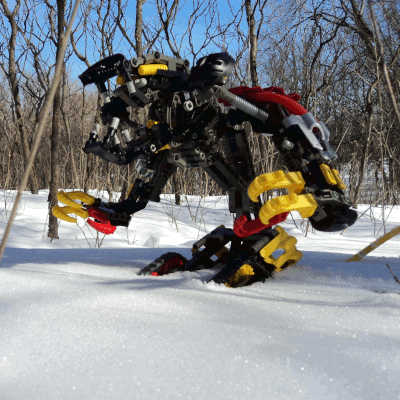 Photo of a Kuma Nui in the snow. It is a creature standing on a pair of treads with two powerful clawed arms, with a big toothy rat face.