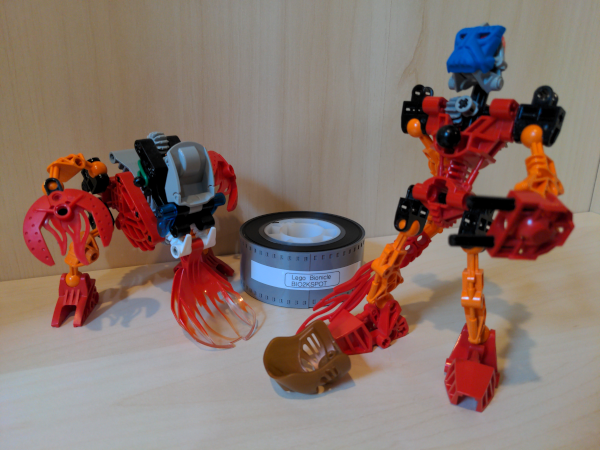 Tahu and Tahnok toys posed in front of the film reel.